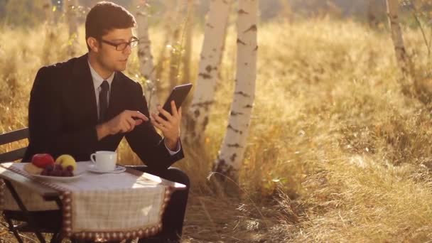 Człowiek za pomocą tabletu podczas śniadania — Wideo stockowe