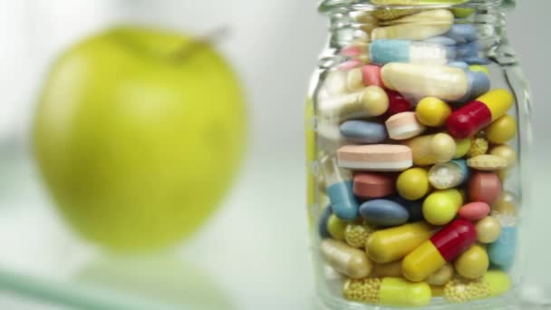 Fruta natural frente a botella de píldoras saludables o artificiales — Vídeos de Stock
