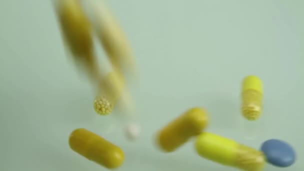 Colorful Medical Pills Falling on White Glass Background — Stock Video