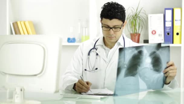 Портрет улыбающегося доктора, смотрящего на рентген — стоковое видео