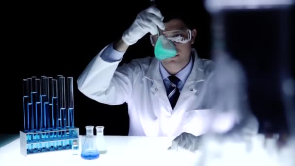 Вчений в лабораторії тримає склянку струшуючи — стокове відео