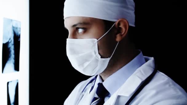 Cirujano joven buscando escáneres de rayos X — Vídeo de stock
