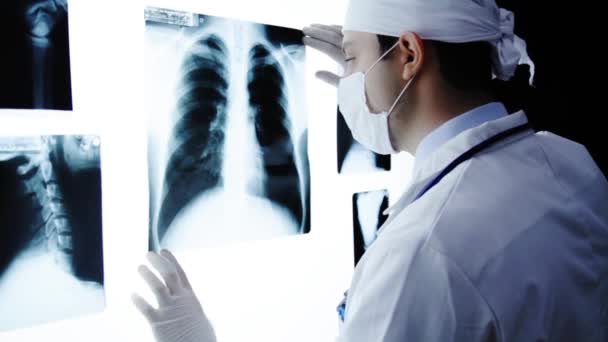 Cirujano joven examinando rayos X antes de la cirugía — Vídeos de Stock