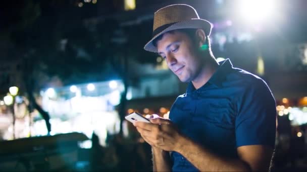 ハンサムな男のスマート フォン都会のダウンタウンの夜を入力光通信技術 4 g 受信テキスト メッセージ Sms アプリ旅行アプリケーション ソーシャル ネットワークのブロガー Uhd — ストック動画