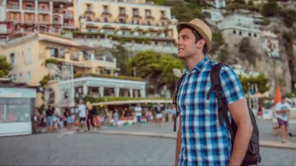 Pohledný mladý muž turistický ruch cestování město Evropa pláž dobrodružství cíl úsměv šťastný svobodný batoh klobouk svoboda životní styl UHD — Stock video