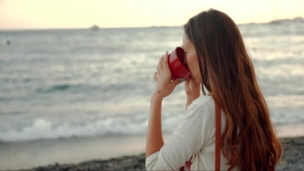 Schöne junge Frau trinkt Kaffee Strand mit Meerblick Boote Pier entspannt Urlaub Freiheit Lifestyle Reisen uhd — Stockvideo