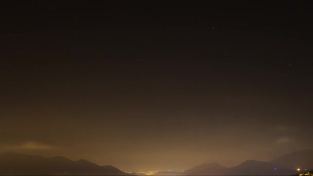 Краєвид нічного міста з хмарами на зоряне небо — стокове відео