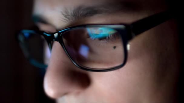 Intelligenter junger Mann Brille arbeitet an Computerbildschirm hacken Eingabe Hacker Software-Entwickler Entwicklung professionelles Geschäft close up Multimedia-Augen Reflexion uhd — Stockvideo