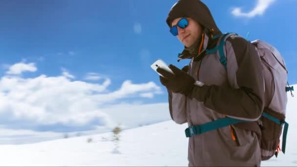 Caminante con teléfono móvil en el pico de la montaña — Vídeos de Stock