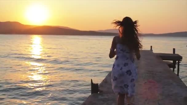 Modelo femenino corriendo hacia el atardecer — Vídeo de stock