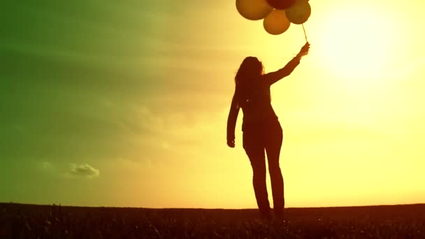 Frau mit Luftballons läuft auf Wiese — Stockvideo