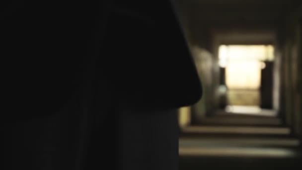 Чоловік у костюмі стоїть у темному коридорі — стокове відео