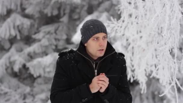 Man bevriezing in winter forest — Stockvideo