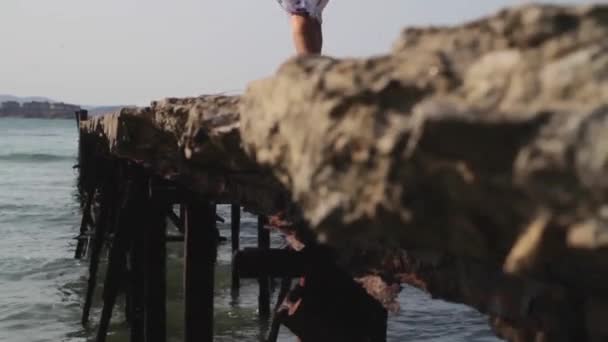 Woman walking on jetty near the ocean — Stock Video