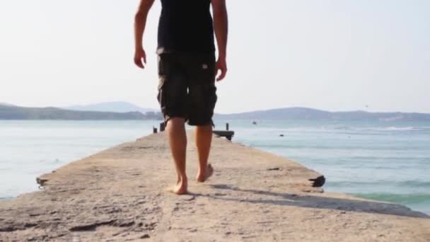 桟橋の上を歩いて若い男 — ストック動画
