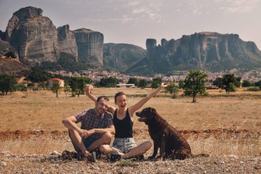 Beautiful couple of tourists in Greece with the Meteora Monaster clipart