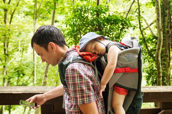 Senderismo familiar activo con 1,5 años niño en el portador en el fondo de una naturaleza . — Foto de Stock