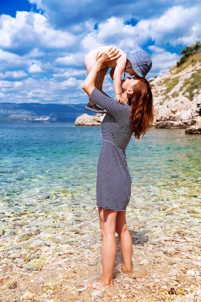 Молодая красивая мать и ее восхитительный сын развлекаются на пляже . — стоковое фото