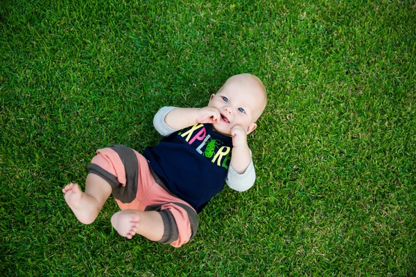 Feliz menino adorável na grama — Fotografia de Stock