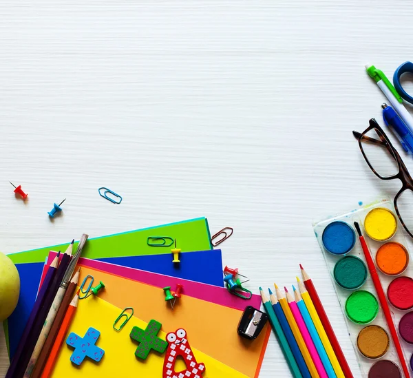 Conjunto escolar e material de escritório conjunto com cadernos lápis pincel colorido papel pintura tesoura figuras e maçã sobre fundo de madeira branca. De volta à escola ou conceito de arte ou educação — Fotografia de Stock