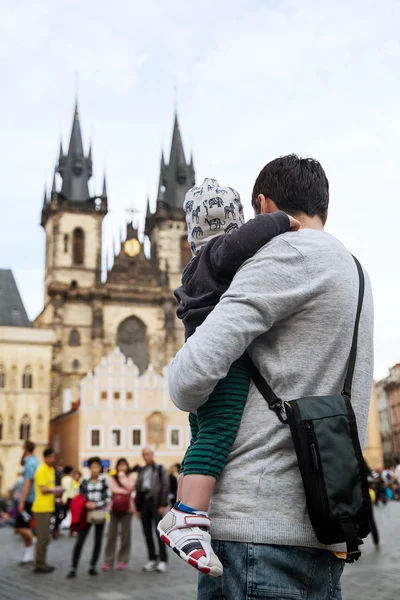 Rodina turistů: otec a jeho syn na pozadí kostela Panny Marie před Tynem na starém náměstí v Praze, Česká republika. — Stock fotografie