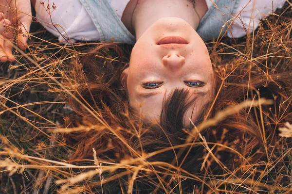 Beauty ung kvinna med brunt hår i gyllene fält vid solnedgången. — Stockfoto