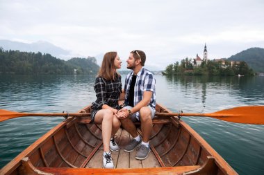 Genç çift turist ahşap teknede Lake Bled, Slovenya.