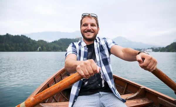 Tourist traveling by traditional wooden boat on the Lake Bled, Slovenia. — Stock Photo, Image