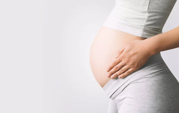 Hamile Kadın Beyaz Arka Planda Göbeğinin Üstünde Ele Tutuşuyor Hamileliğin — Stok fotoğraf