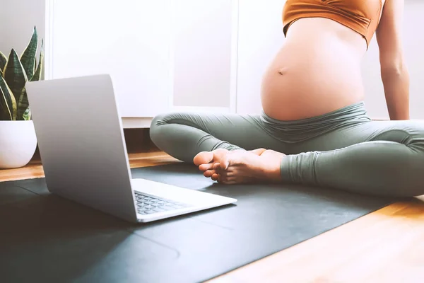 Detailní Břicho Těhotné Ženy Praktikující Jógu Online Doma Notebookem Očekávající — Stock fotografie