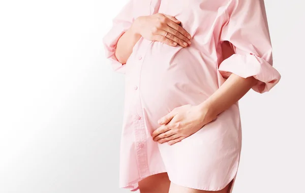 Close Van Mooie Zwangere Vrouw Roze Shirt Jurk Houdt Handen — Stockfoto