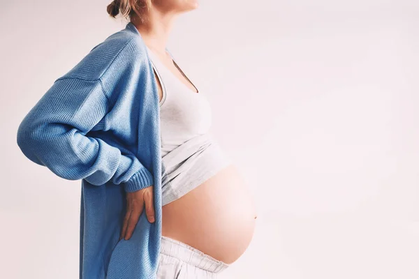 漂亮的孕妇抱着她的腹部白色的背景 孕妇在怀孕期间等待分娩 产妇保健概念 访问医生和妇科检查 — 图库照片