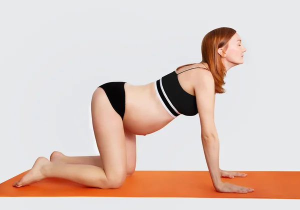 Беременная женщина занимается йогой и расслабляет — стоковое фото