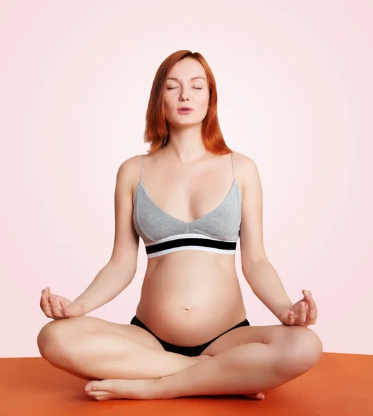 Mujer embarazada haciendo yoga y relajándose —  Fotos de Stock