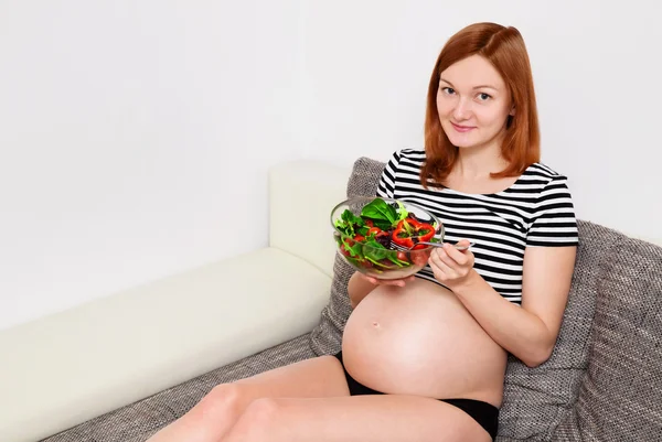 Gravid kvinna med en skål med grönsaker — Stockfoto