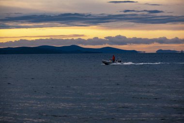 Gün batımında denizde sürat teknesi