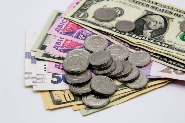 Ukrayna parası ve arka planda Amerikan doları. Banknotlar ve metal paralar bir arada.