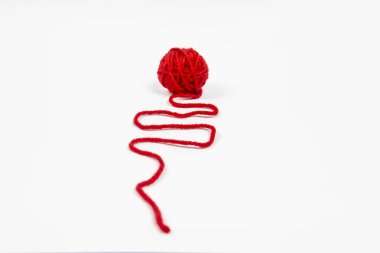 Beyaz arkaplana karşı kırmızı iplik. Kırmızı iplik yumağı beyaza izole edilmiş