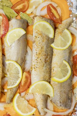 Fırında limonlu, domatesli, havuçlu ve soğanlı fırında pişmiş çiğ hake. Öğlen ya da akşam yemeği için lezzetli balık, diyet için mükemmel. Sebzeli pişirmek için lezzetli ve taze balık..