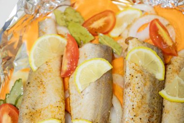 Fırında limonlu, domatesli, havuçlu ve soğanlı fırında pişmiş çiğ hake. Öğlen ya da akşam yemeği için lezzetli balık, diyet için mükemmel. Sebzeli pişirmek için lezzetli ve taze balık..