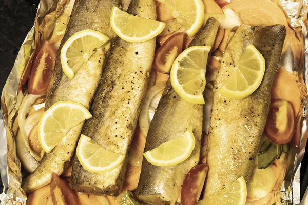 Fırında limonlu, domatesli, havuçlu ve soğanlı fırında pişmiş çiğ hake. Öğlen ya da akşam yemeği için lezzetli balık, diyet için mükemmel. Sebzeli pişirmek için lezzetli ve taze balık..