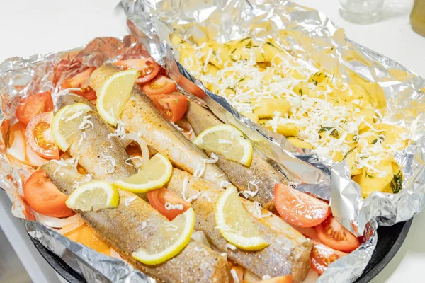 Fırında limonlu, domatesli, havuçlu ve soğanlı fırında pişmiş çiğ hake. Öğlen ya da akşam yemeği için lezzetli balık, diyet için mükemmel. Sebzeli pişirmek için lezzetli ve taze balık..