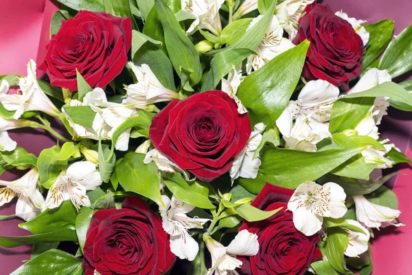 Kırmızı güller ve beyaz alstromerya çiçekleri kapanıyor.
