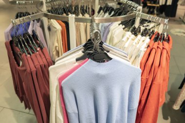 Alışveriş merkezinde askılarda kadın kazakları.