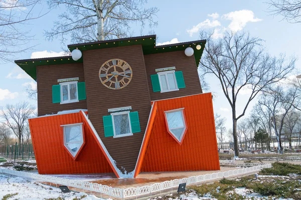 Maison à l'envers sur le fond de la ville Image En Vente