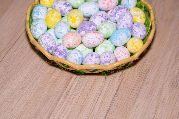 Uova colorate pasquali in un nido da vicino su uno sfondo di legno — Foto Stock