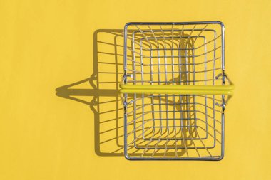 Renkli arka planda sert gölgeli çelik süpermarket sepeti