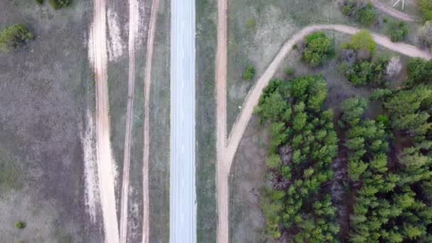 Vue aérienne de la route entre la forêt. Beau paysage routier, arbres verts. vidéo d'un quadrocopter — Video