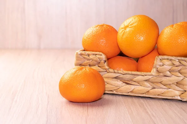 Mandarinas maduras en una canasta sobre un fondo de madera — Foto de Stock