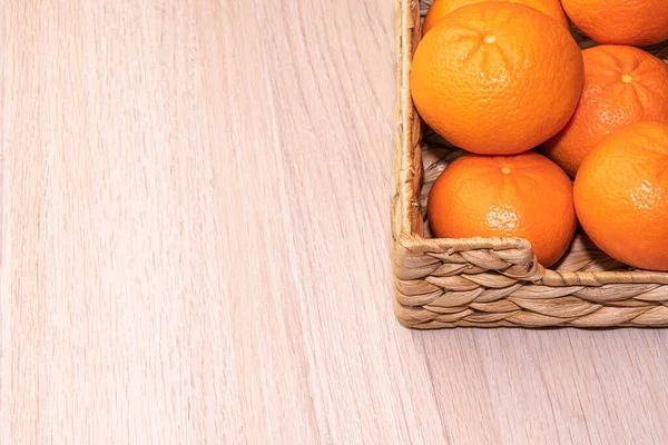 Mandarinas maduras en una canasta sobre un fondo de madera — Foto de Stock